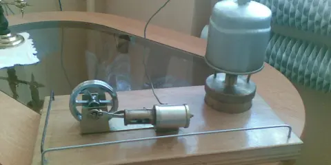Miniaturowy silnik parowy z prądnicą, gotowy do pracy.