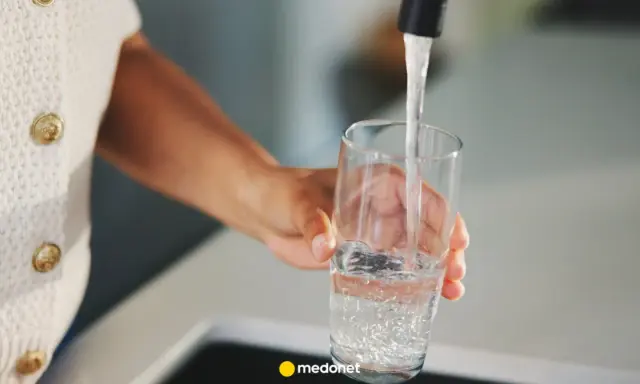 Ręka nalewa wodę do szklanki. Zastanawiasz się, kiedy skończy się woda pitna? Dbajmy o zasoby.