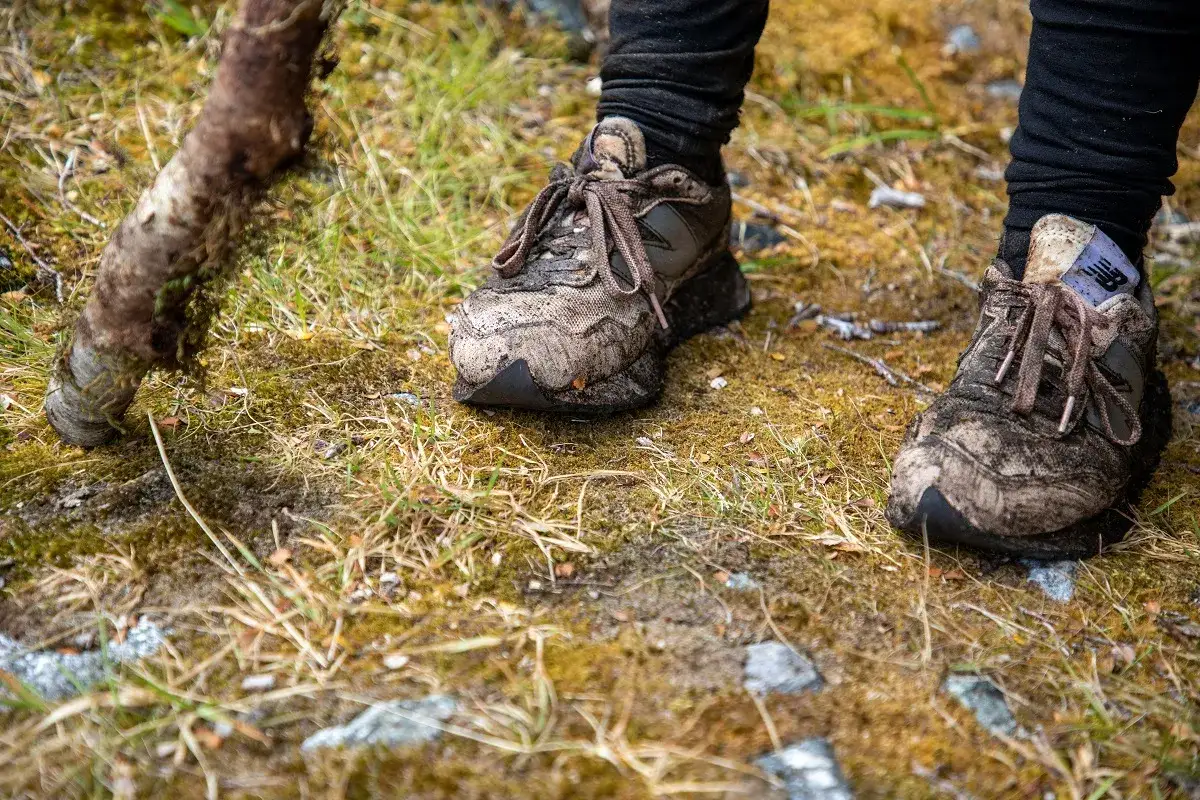 Błotniste buty sportowe New Balance po wędr&oacute;wce po lesie. Zastanawiasz się, czym czyścić buty?